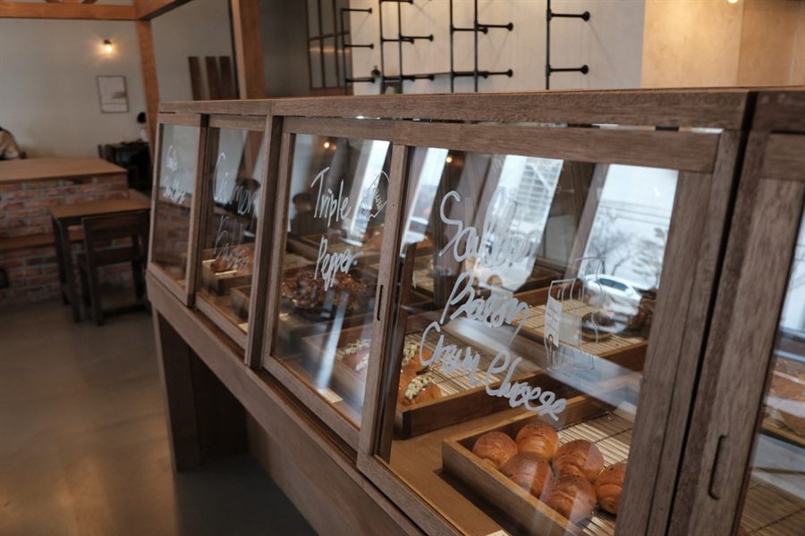 木の販売台とペンダント照明のある店内